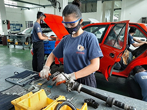 A student practices vehicle disassembly